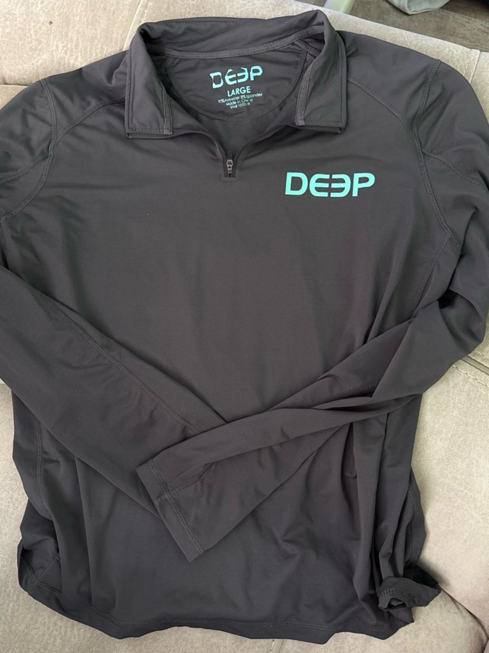 Deep Men's Black Long-Sleeve Performance Shirt with Teal Logo